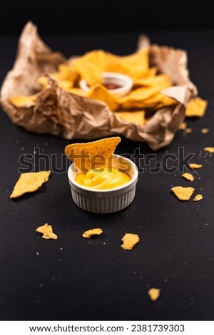 Nachos and sauce. Cheese sauce with nachos. Ketchup with nachos. Royalty-Free Stock Photo #2381739303