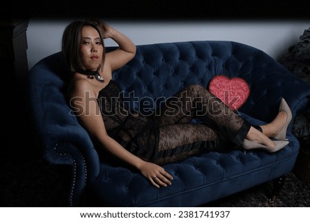 Photo shoot of a beautiful Vietnamese model on a sofa, with red heart and black lace outfit
