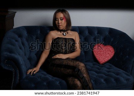 Photo shoot of a beautiful Vietnamese model on a sofa, with red heart and black lace outfit