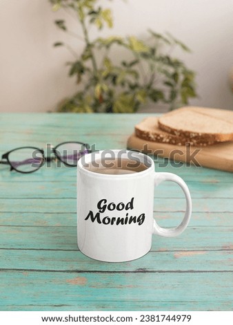 A cup of coffee with the words GOOD MORNING on a wooden background.