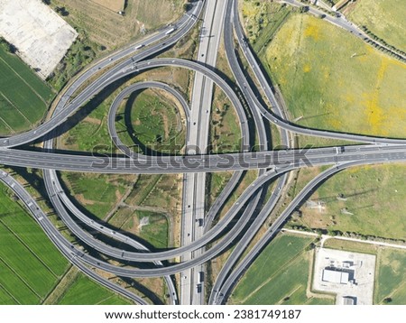 Aerial view of a four-lane highway intersection with a car driving along one of the lanes Royalty-Free Stock Photo #2381749187