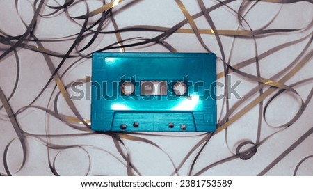 Green cassettes and ribbons are scattered on a gray background