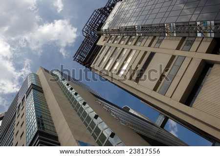 clouds reflection on highrise glass building against sky