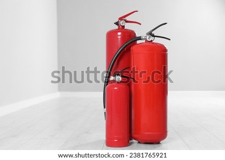 Fire extinguishers on floor indoors, space for text Royalty-Free Stock Photo #2381765921