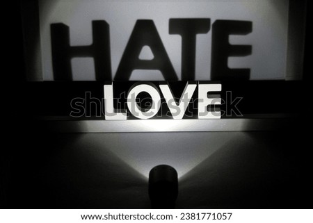 The wording love sign in the dark room with hate shadow on the wall
