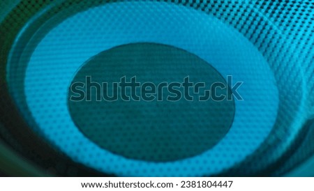 Subwoofer with membrane neon blue light moving vibrating, macro sound bass circles, abstract background. Royalty-Free Stock Photo #2381804447