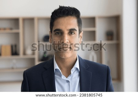 Serious handsome Indian executive man in formal cloth head shot portrait. Positive middle aged businessman, business professional, CEO, entrepreneur looking at camera, posing in office Royalty-Free Stock Photo #2381805745
