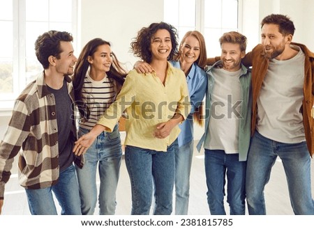Portrait of a group of excited happy young friends students or colleagues having fun hanging together at home. Guys and girls standing in a row hugging enjoying meeting. Friendship concept. Royalty-Free Stock Photo #2381815785