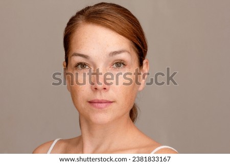 Portrait of caucasian middle aged woman of 40s looking at camera on gray background Royalty-Free Stock Photo #2381833167