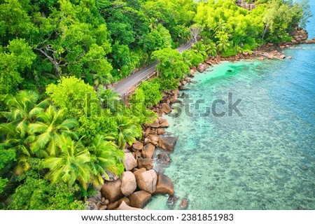 Bird eye drone of baie lazare beach, granite stones, turquoise water, coconut palm trees, public road, sunny day, Mahe Seychelles Royalty-Free Stock Photo #2381851983