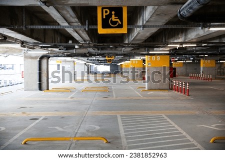 Bright and spacious underground parking garage showcasing accessibility features, clearly marked spaces, and urban architectural details.