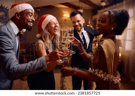 Multiracial group of cheerful friends having fun while toasting with champagne during New Year's party, Royalty-Free Stock Photo #2381857725