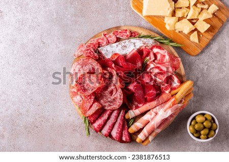 Charcuterie board. Antipasti appetizers of meat platter with salami, prosciutto crudo or jamon and olives Royalty-Free Stock Photo #2381876513