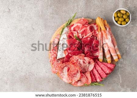 Charcuterie board. Antipasti appetizers of meat platter with salami, prosciutto crudo or jamon and olives Royalty-Free Stock Photo #2381876515