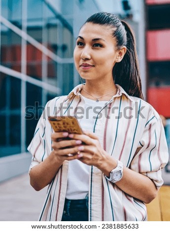 Chinese hipster girl updating profile in app on digital mobile phone