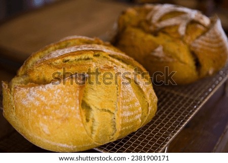 Close-up shot of freshly baked artisan breads cooling on a wire rack in a rustic kitchen setting
