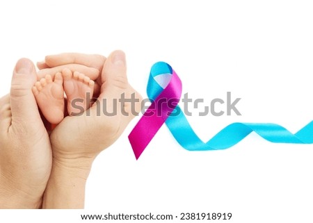 World Prematurity Day on 17th November. Woman hand with a baby feet . Motherhood and care. Royalty-Free Stock Photo #2381918919
