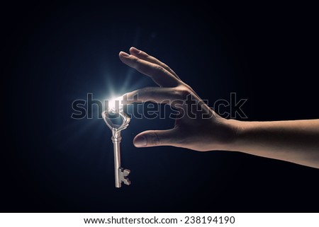 Close up of human hand catching golden key