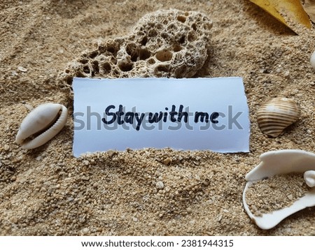 The writing stay with me on the beach sand background.