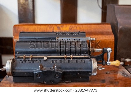 Ancient iron calculator, Old vintage adding machine or arithmometer. Royalty-Free Stock Photo #2381949973