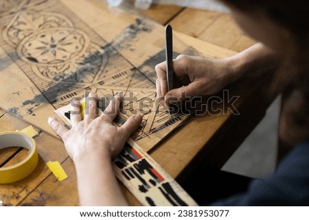 Adult Caucasian Female Expertise Cutting a Wall Stencil Design in her Studio Workshop Royalty-Free Stock Photo #2381953077