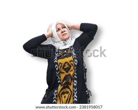Asian Muslim woman in hijab, expression holding back pain with hands holding head. Isolated on white background