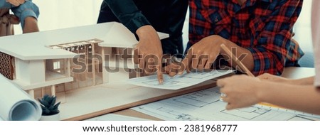 Skilled architect engineer team meeting pointing at blueprint while professional interior designer analysis and brainstorming about house structure. Creative design and teamwork concept. Burgeoning.