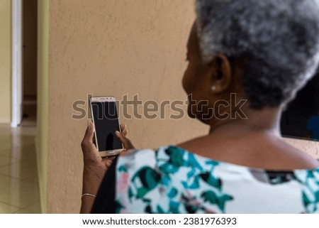 Retired elderly black woman holding a cell phone