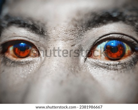 selective focus on two human eyes red blue color with blurred face.it is edited picture