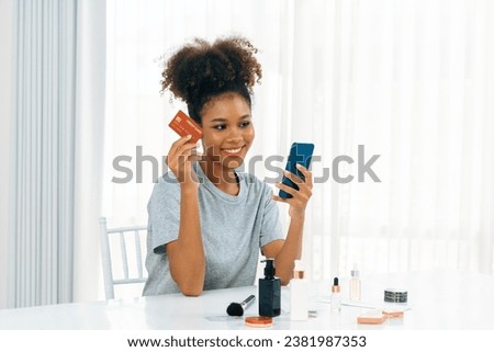 Young happy woman buy product by online shopping at home while ordering items from the internet with credit card online payment system protected by crucial cyber security from online store platform Royalty-Free Stock Photo #2381987353