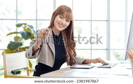 Asian professional successful young female businesswoman creative graphic designer in casual fashionable suit outfit sitting smiling working drawing sketching with stylus pen and computer in office. Royalty-Free Stock Photo #2381987867
