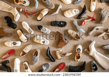 Different female shoes abstract arrangement on beige carpet flooring fashion shopping background. Woman femininity footwear random lying on floor unreasonable consumption vogue trendy backdrop Royalty-Free Stock Photo #2381998789