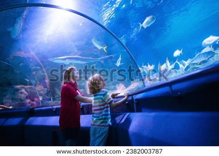 Family in aquarium. Kids watch tropical fish, marine life. Child looking at sea animals in large oceanarium. Ocean life museum. School or vacation day trip to aqua park. Royalty-Free Stock Photo #2382003787