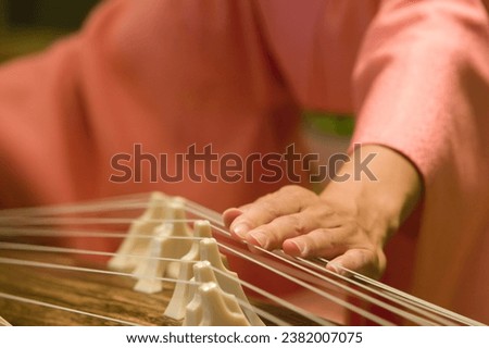 Kobe, Japan.  August 3, 2004 A close up of a female musician's hands and fingers while she plays the koto, a 13 string pluck zither that is the national instrument of Japan. Royalty-Free Stock Photo #2382007075