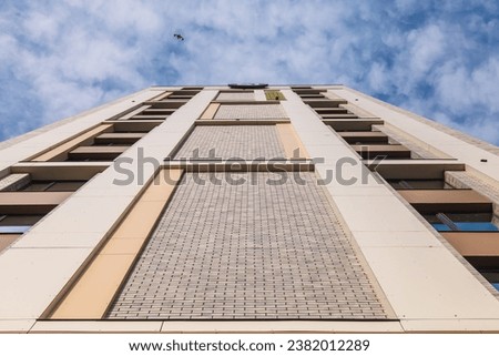 Facade of a high-rise multi-storey residential building decorated with modern materials against the sky Royalty-Free Stock Photo #2382012289