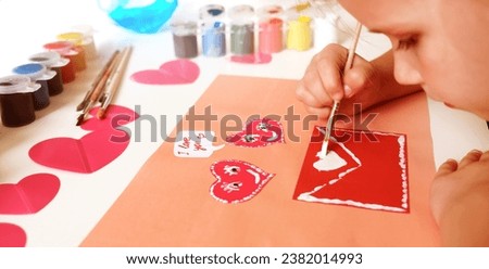 Child created homemade greeting card. A little girl painted and colored card with funny hearts. Gift for Mothers Day or Valentines day. Arts and crafts concept. Royalty-Free Stock Photo #2382014993