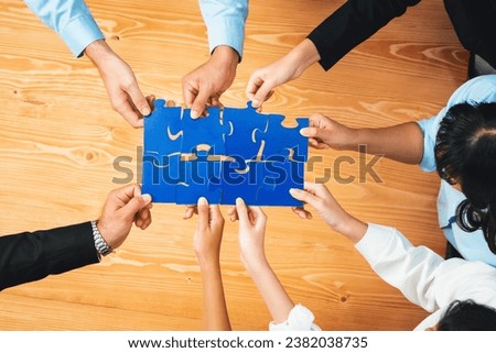 Top view multiethnic business people holding jigsaw pieces and merge them together as effective solution solving teamwork, shared vision and common goal combining diverse talent. Habiliment Royalty-Free Stock Photo #2382038735