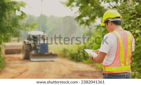 Asian male foreman check quality road work at construction site.