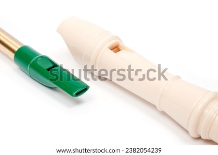 Irish whistle and block flute are longitudinal flutes with a whistle device and playing holes. Royalty-Free Stock Photo #2382054239