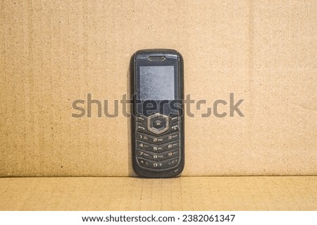 old cellphone with a plain brown background
