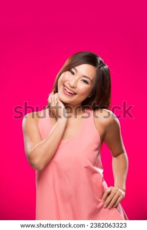 Portrait of happy Asian Woman. Young fresh Chinese female model on bright pink background. 
