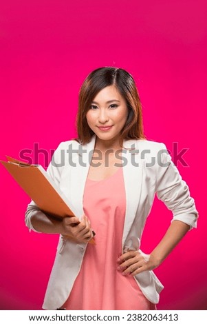 Portrait of happy Asian Business Woman. Young fresh Chinese female model on bright pink background. 