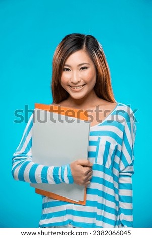 Portrait of happy Asian Woman. Young fresh Chinese female model on bright blue background. 