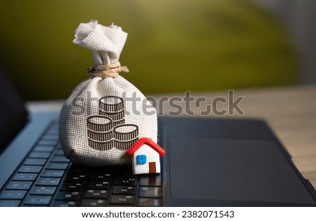 House and a money bag and on the computer keyboard. Make a deal. Property Insurance. Taxes. Community budget. Financial support. Housing stock and infrastructure. Profit. Real estate investment. Royalty-Free Stock Photo #2382071543