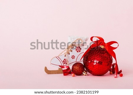 Christmas ball with skates on colored background. decoration bauble with ribbon bow with copy space.