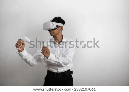 Young man in neat white shirt using virtual reality headset. Isolated on white background studio portrait. VR, future, gadgets, technology, online education, learning, video game concept