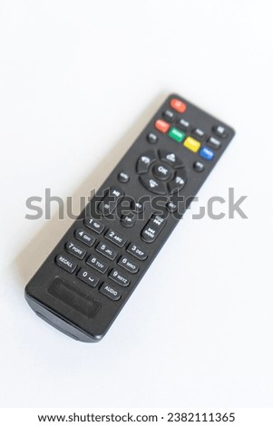 Black television remote on white background
