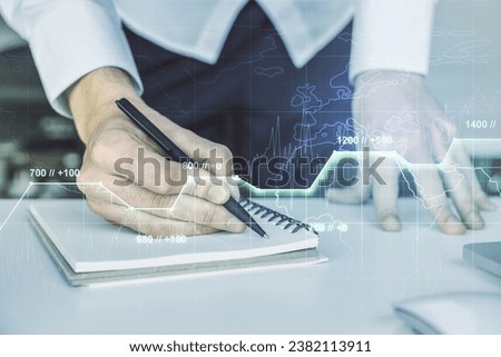 Abstract creative stats data concept with hand writing in notebook on background with laptop. Multiexposure