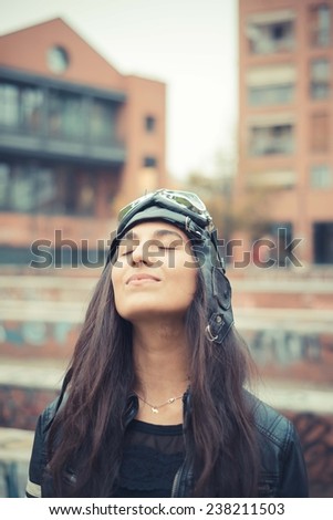 aviator young beautiful brunette woman with cap and glasses in the city