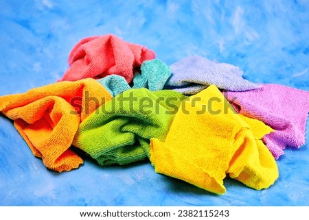 seven colored rainbow microfiber cloths lie crumpled together for cleaning anything, on a blue background Royalty-Free Stock Photo #2382115243